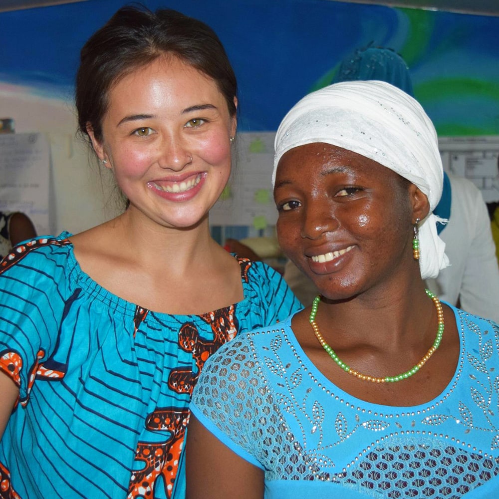 Two women wearing turquoise smiling at the camera