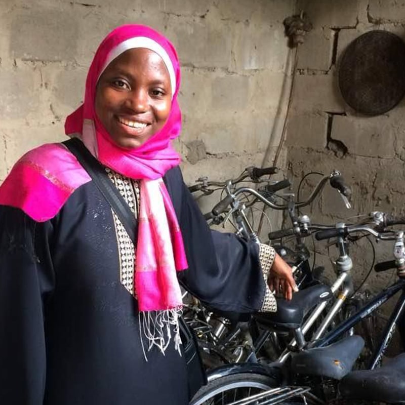 A young woman entrepreneur standing in front of a collection of bicycles