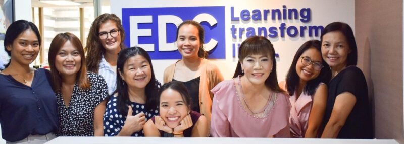 Header-image_Promoting-gender-equality-and-inclusivity-with-EDC-in-Bangkok-e1531510556598 Eight women smiling and posing together in front of an EDC Learning Transforming Lives sign.
