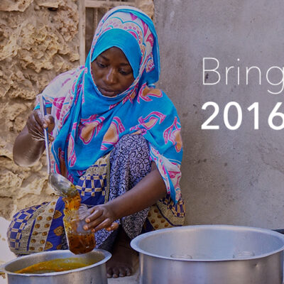 Woman in colorful attire ladles food into a jar beside pots; text reads "Bring on 2016.