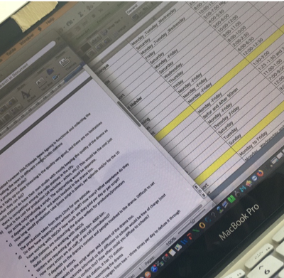 A MacBook Pro screen displaying a document and a spreadsheet side by side.